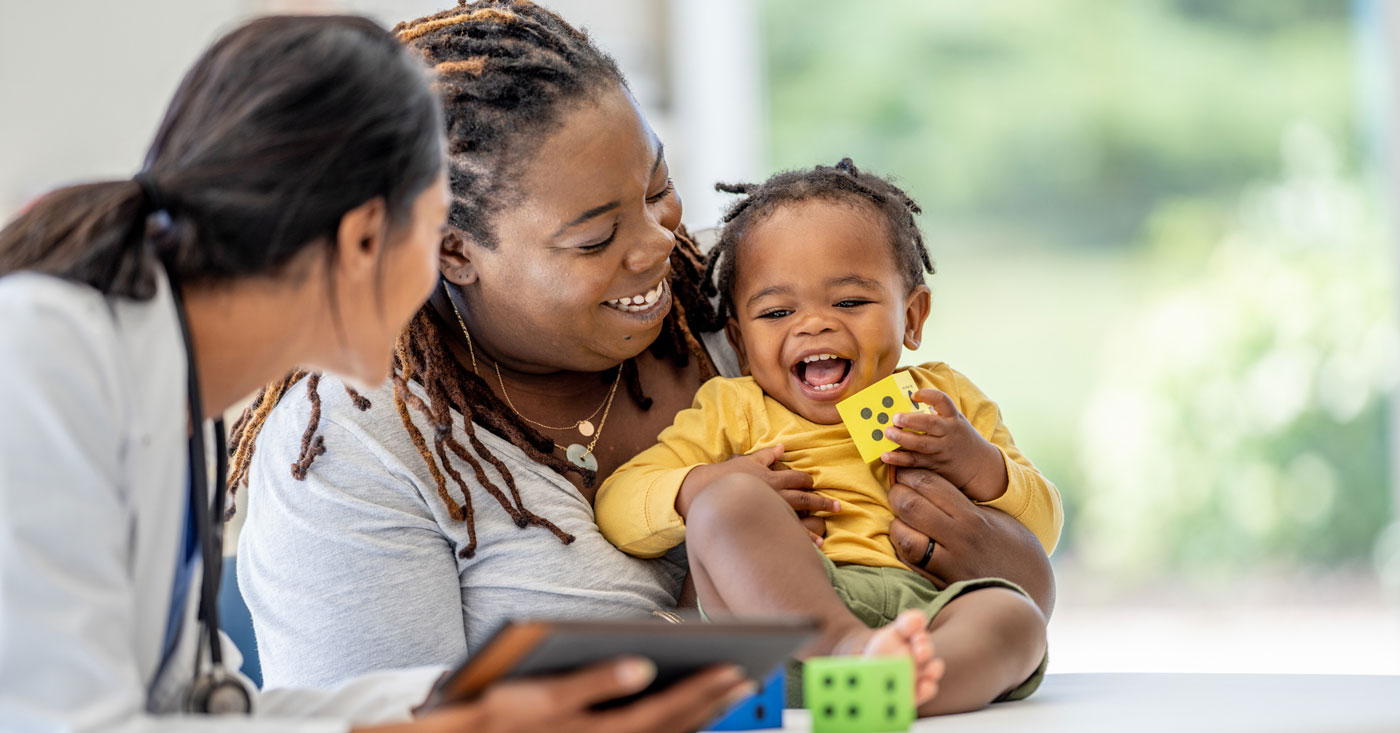 Mom and son smiling with a pediatrician.
