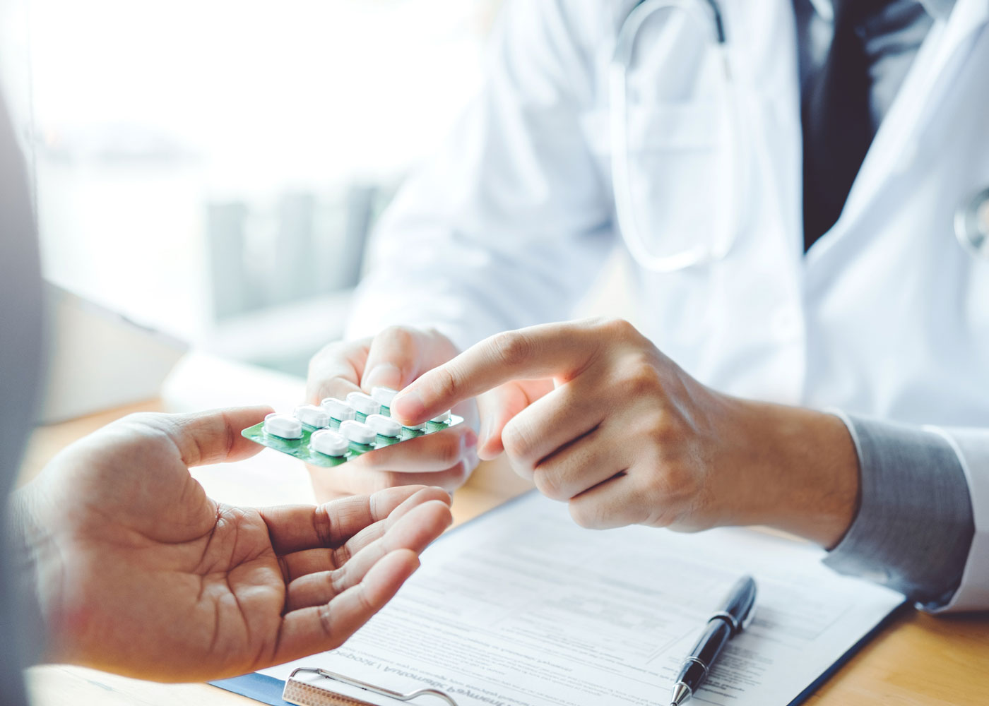 Pharmacist pointing at pill packet.