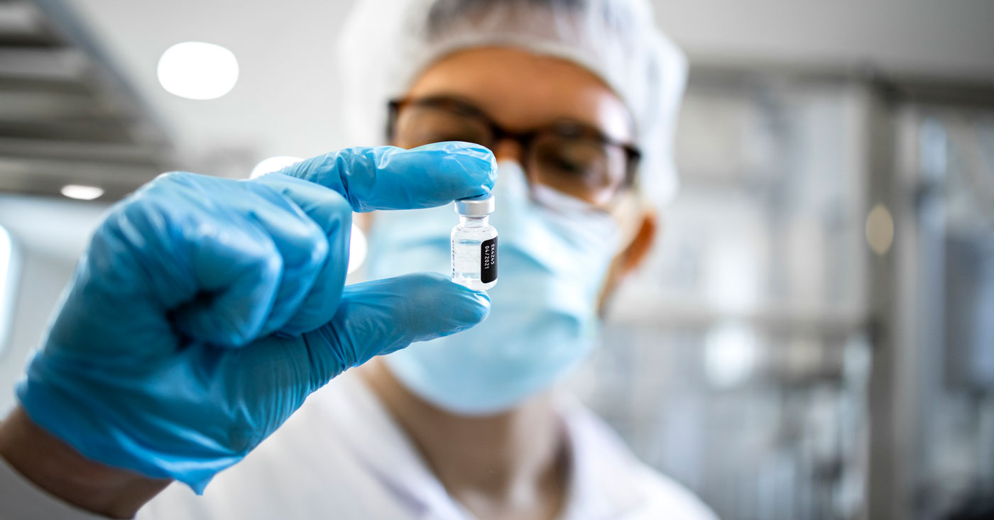 Pharmaceutical worker holding a vial.