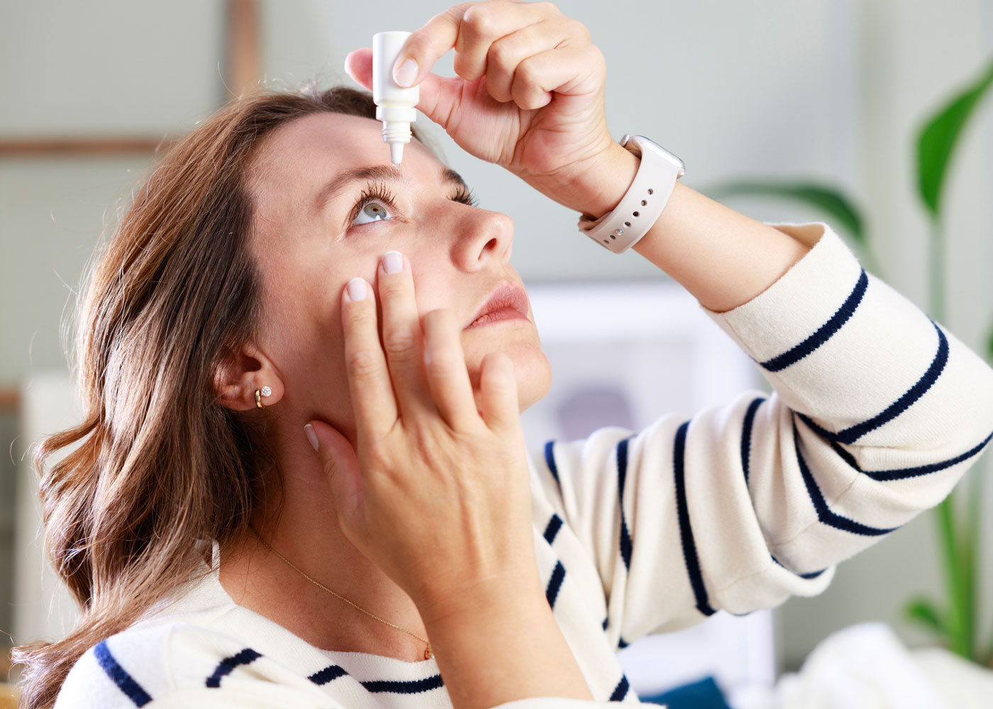 Woman applying eye drops.