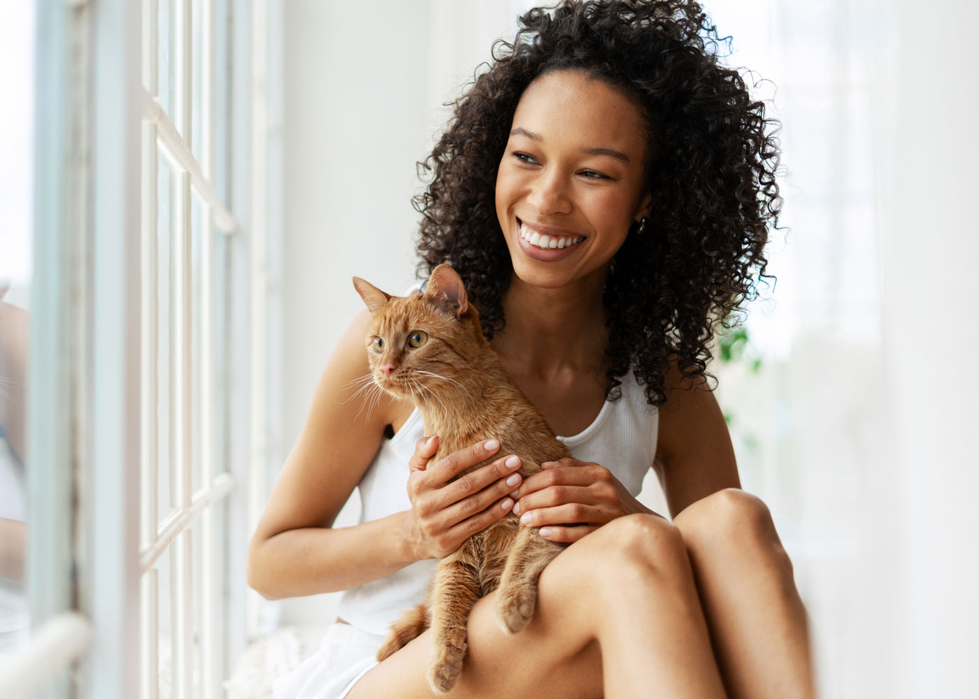 Woman holding orange cat.