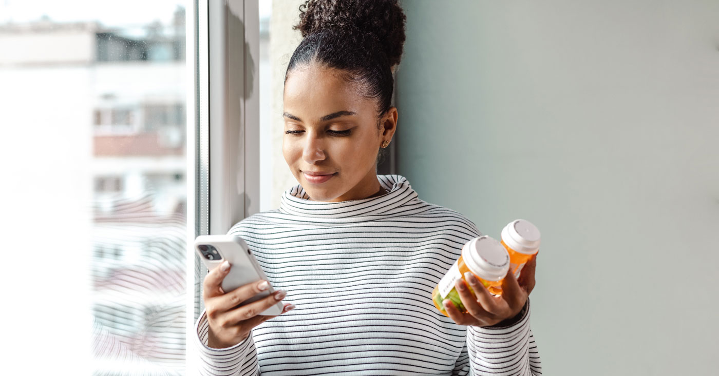 Woman holding pill bottles.